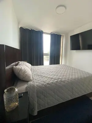 a bedroom with a bed with blue curtains and a window at Barranco Bohemio, Modern and Bright Apartment in Lima
