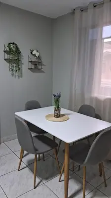 a dining room table with chairs and a white table at Sweet Home in Lima