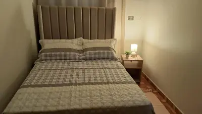 a bedroom with a large bed with a large headboard at Sweet Home in Lima