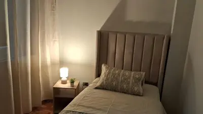 a bedroom with a bed and a lamp on a night stand at Sweet Home in Lima