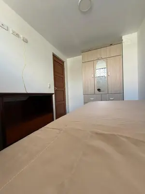 an empty room with a large bed and a window at Habitacion San Borja in Lima