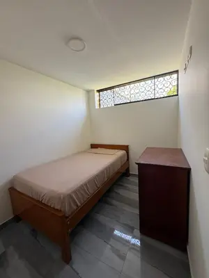 a small bedroom with a bed and a window at Habitacion San Borja in Lima