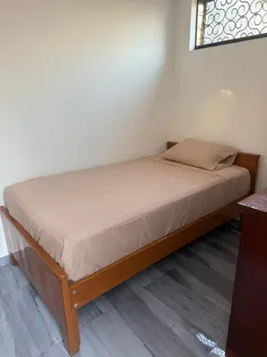 a bed in a room with a wooden bed frame at Habitacion San Borja in Lima