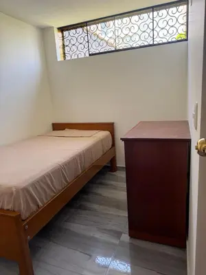 a bedroom with a bed and a dresser and a window at Habitacion San Borja in Lima