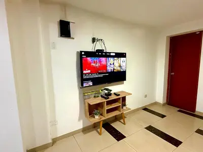 a living room with a flat screen tv on a wall at Comfort House in Lima