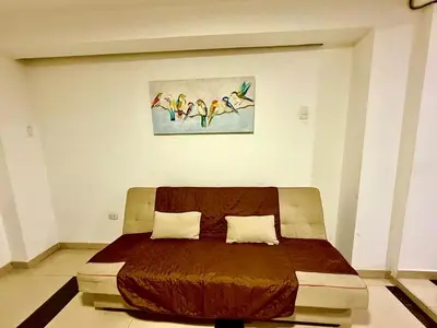 a bed in a room with a painting on the wall at Comfort House in Lima