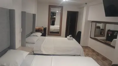a room with four beds and a mirror at HotelesR20 in Lima
