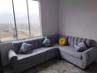 a couch with pillows sitting in a room with windows at Ocean Glips II in Punta Negra
