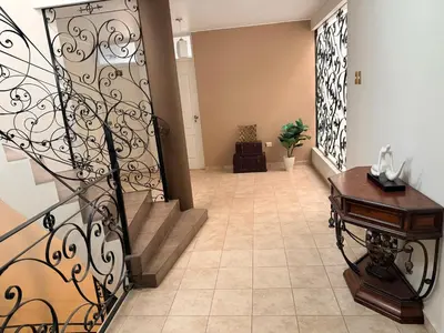 a hallway with a staircase with a wrought iron railing at Huacachina Boutique Hotel in Ica