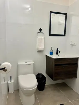 a white bathroom with a toilet and a sink at Mini Patria - Cozy apartment in Barranco in Lima