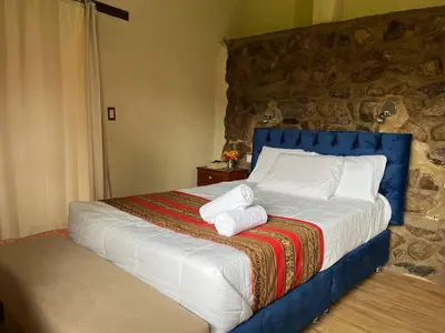 a bedroom with a bed with towels on it at La Casa de Tay in Urubamba