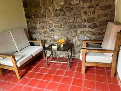 a living room with two chairs and a table with flowers at La Casa de Tay in Urubamba