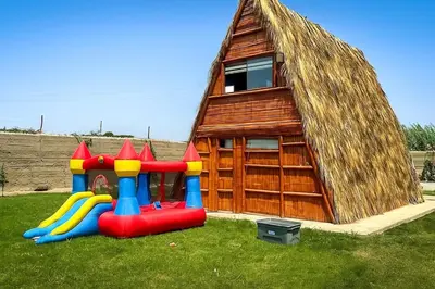 a small house with a playground in the grass at Cabaña las Palmeras de Chincha