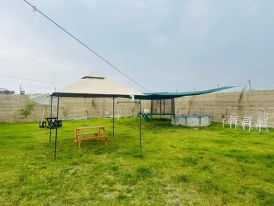 a tent with a picnic table and chairs in a field at Cabaña las Palmeras de Chincha
