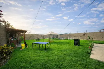 a picnic table in a yard with a gazebo at Cabaña las Palmeras de Chincha