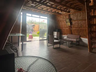 a room with chairs and a table and a window at Cabaña las Palmeras de Chincha