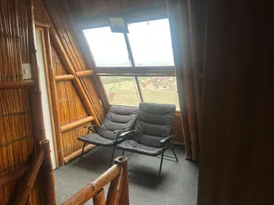 a chair sitting in a room with a window at Cabaña las Palmeras de Chincha