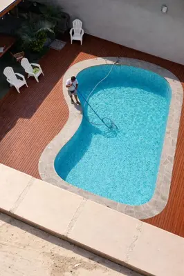 a man isblocking a swimming pool with a hose at Casa Matta in Sunampe