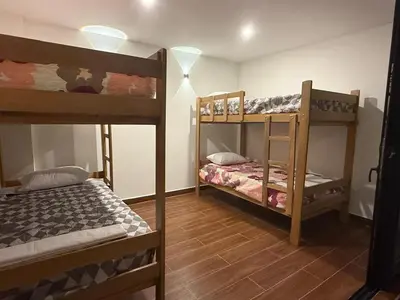 two bunk beds in a room with wooden floors at Casa LeBlanc in Ica