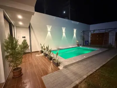 a swimming pool in a backyard at night at Casa LeBlanc in Ica