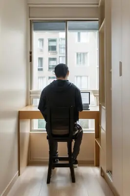 a man sitting in a chair at a desk with a laptop at E SuiteCost FreeParking San Miguel 1B 708 in Lima