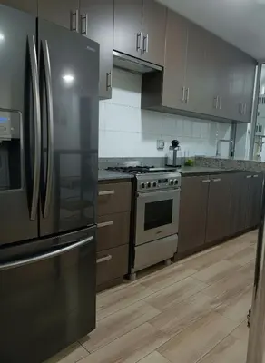 a kitchen with stainless steel appliances and wooden cabinets at E SuiteCost FreeParking San Miguel 1B 708 in Lima