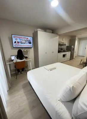 a room with a bed and a person sitting at a desk at E Free Parking Patio Privado Barranco 1B 109 in Lima