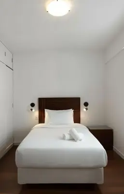 a bedroom with a white bed with a wooden headboard at E Larcomarzone FamilyTourist Laundry 3B 503 in Lima