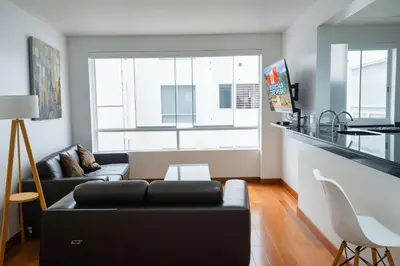 a living room with a black couch and a window at E Suite Tourist free Parking Miraflores 1B 503 in Lima