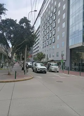 a city street with cars parked in front of buildings at E Suite Tourist free Parking Miraflores 1B 503 in Lima