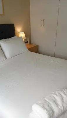a bedroom with a white bed and a night stand at E Free Parking Wifi Pro Laundry 1B 204 in Lima