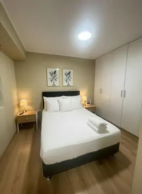 a bedroom with a large white bed with two night stands at E Free Parking Wifi Pro Laundry 1B 204 in Lima