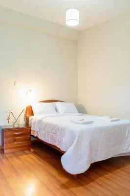 a bedroom with a large bed with white sheets at Valle Hermoso in San Ramón