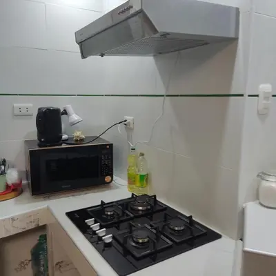 a kitchen with a stove and a microwave at La Palmera Apartment in San Bartolo