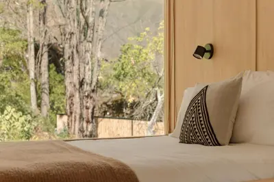 a bedroom with a bed with a large window at Earth Tones Tiny Homes & Suites in Ollantaytambo
