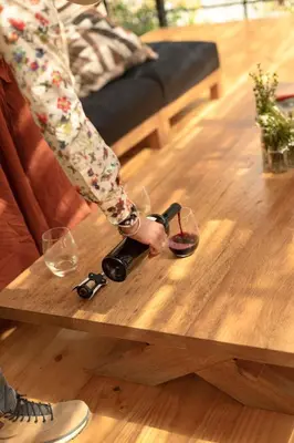 a person is holding a pair of glasses on a table at Earth Tones Tiny Homes & Suites in Ollantaytambo