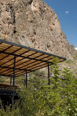 a roof on a building in front of a mountain at Earth Tones Tiny Homes & Suites in Ollantaytambo