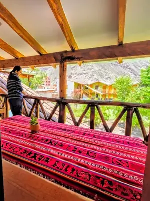 a woman standing on a balcony looking out the window at Loft Rústico 03 en Valle Sagrado in Urubamba