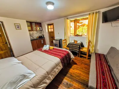 a bedroom with a bed and a table and a window at Loft Rústico 03 en Valle Sagrado in Urubamba