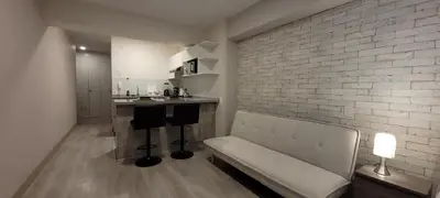 a living room with a bench and a brick wall at Loft de Luxe - cerca a San Borja & San Isidro in Lima