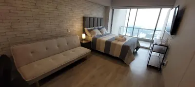 a bedroom with a bed and a couch and a brick wall at Loft de Luxe - cerca a San Borja & San Isidro in Lima