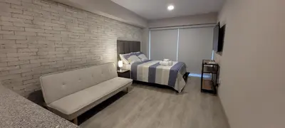 a bedroom with a bed and a couch in a room at Loft de Luxe - cerca a San Borja & San Isidro in Lima