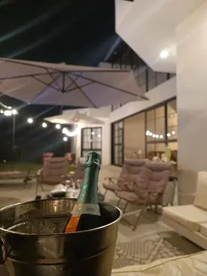 a bottle of champagne in a bucket on a table at Hermosa casa con piscina privada in Asia
