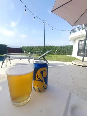 a glass of beer and a can on a table at Hermosa casa con piscina privada in Asia