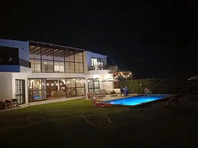a house with a swimming pool at night at Hermosa casa con piscina privada in Asia
