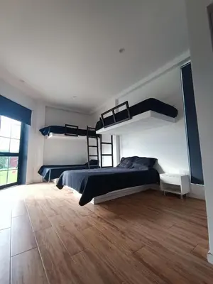 a bedroom with two bunk beds and a wooden floor at Hermosa casa con piscina privada in Asia