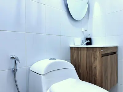 a bathroom with a toilet and a sink and a mirror at Peruvian Apartments La Angostura in Ica
