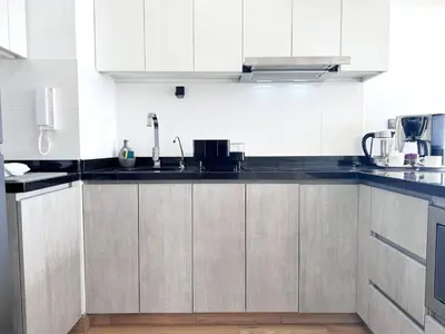 a kitchen with white cabinets and black counter tops at Peruvian Apartments Barranco 1404 in Lima