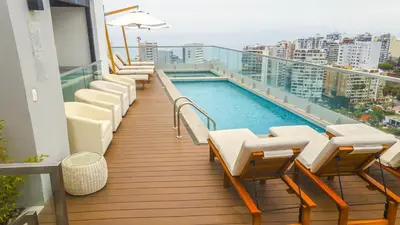 a balcony with chairs and a swimming pool on a building at Peruvian Apartments Barranco 1710 in Lima
