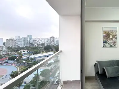 a room with a balcony with a view of a city at Peruvian Apartments Barranco 1710 in Lima